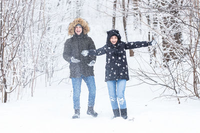 Full length of woman standing on snow covered tree