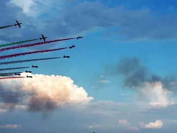 Low angle view of airplanes flying against sky