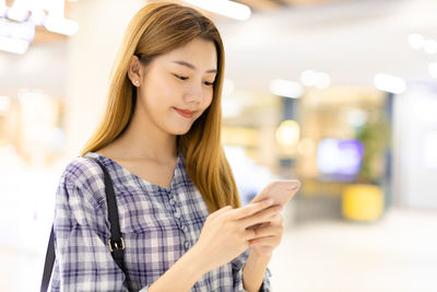 Beautiful young woman using mobile phone