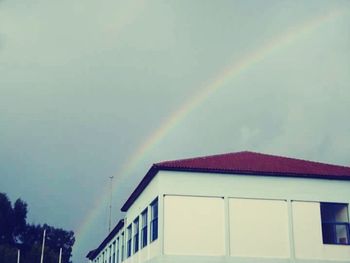 Low angle view of rainbow over buildings