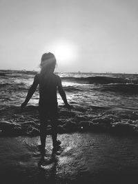 Rear view of woman standing on beach