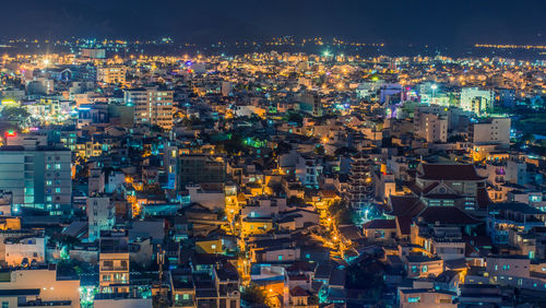 High angle view of illuminated cityscape against sky at night