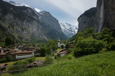 Houses by trees and mountains against sky