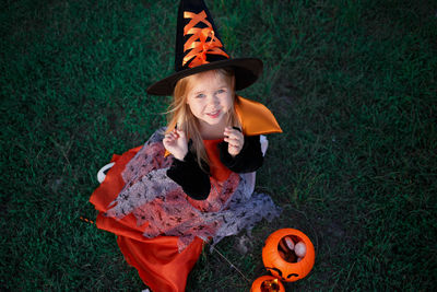 High angle portrait of smiling young woman on grassy field