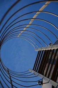 Low angle view of ladder against blue sky