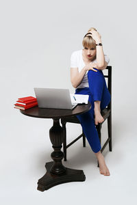 Portrait of young woman sitting on table