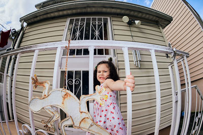 Cute young girl in a summer dress playing in a suburban backyarrd