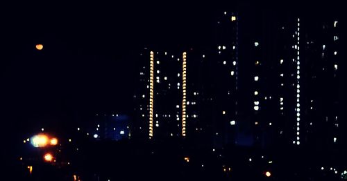 Illuminated city against sky at night