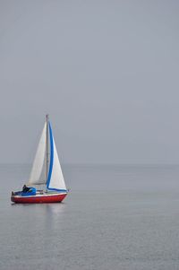 Sailboat sailing on sea against sky