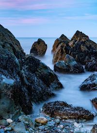 Scenic view of rocks in sea against sky