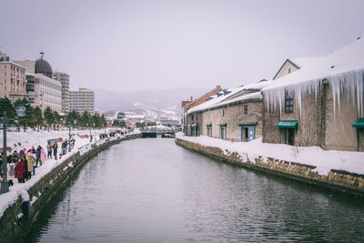 River amidst buildings in city against clear sky