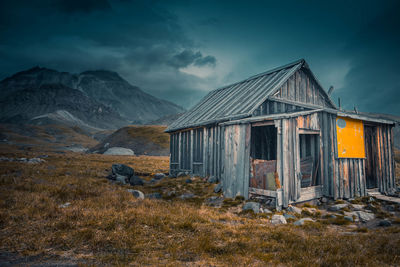 Exterior of abandoned house on mountain against sky