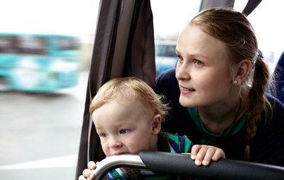 Close-up of mother with cute son sitting in bus