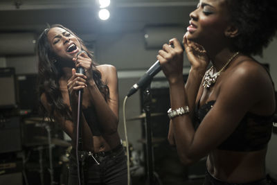 Young women singing in a recording studio