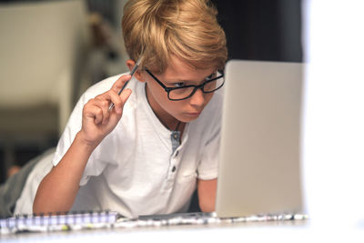 Boy using laptop in living room at home