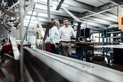 Business people planning while standing at industry