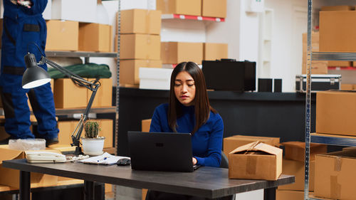 Young woman using laptop at desk in cafe