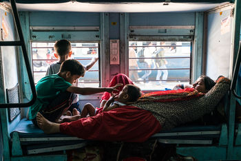 REAR VIEW OF PEOPLE SITTING ON SEAT