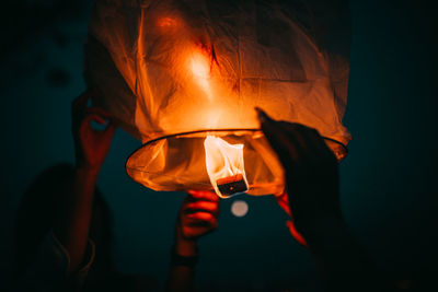 Midsection of man holding lit candle