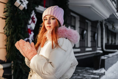 Portrait of young woman standing in city