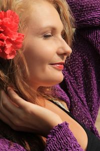 Sunlight falling on young woman wearing red flower