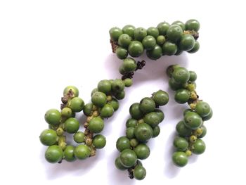 Close-up of green coffee beans over white background