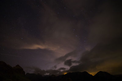 Low angle view of silhouette mountain against sky at night