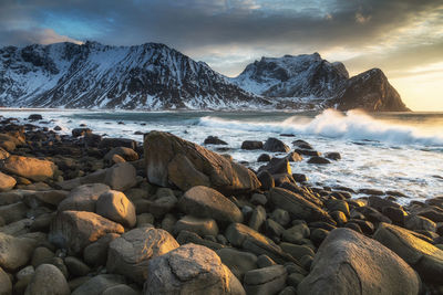 Scenic view of sea by rocks against sky