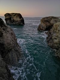 Scenic view of rocks in sea against sky