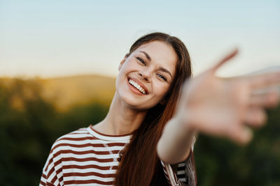 Young woman looking away against sky