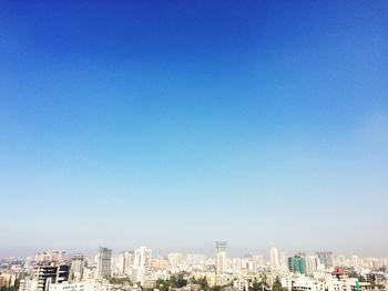 View of cityscape against blue sky