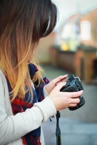 Side view of woman holding camera