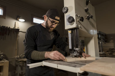 Woodworker working on band saw in workshop