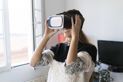 Young woman wearing vr glasses at home