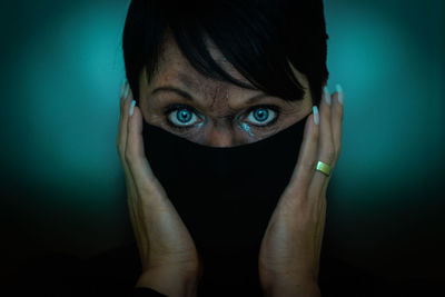Close-up portrait of a woman against black background