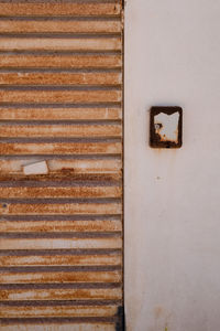 Full frame shot of rusty shutter by wall