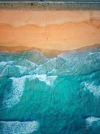 Aerial view of sea waves rushing at beach