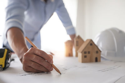 Midsection of man holding paper on table