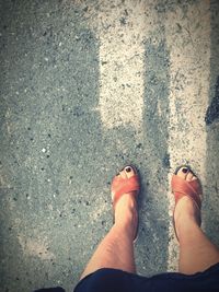 Low section of woman standing on road