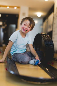 Portrait of boy sitting amidst toy racetrack