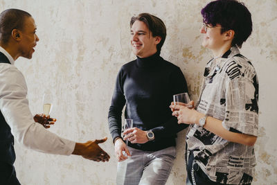 Smiling business colleagues enjoying and having drinks during event at convention center