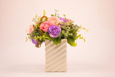 Close-up of rose bouquet on table against white background