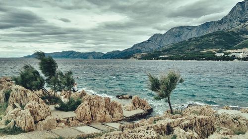 Panoramic view of sea and mountains against sky