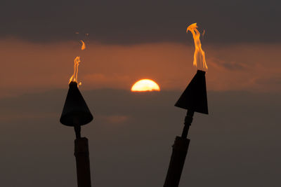 Low angle view of silhouette light against sky during sunset