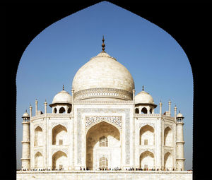 Low angle view of taj mahal seen through arch against clear sky