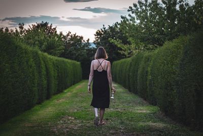 Rear view of woman walking on field