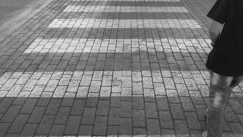 Low section of woman walking on road