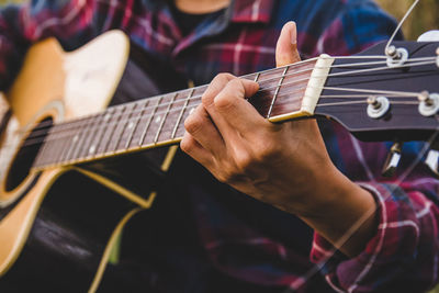 Midsection of man playing guitar