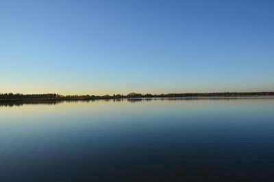 Scenic view of lake against clear blue sky