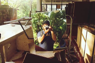 Young man using camera in the mirror